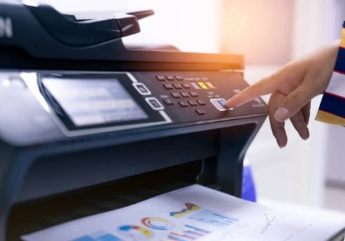 Office worker print paper on multifunction laser printer. Copy, print, scan, and fax machine in office. Modern print technology.  Photocopy machine. Document and paper work. Professional scanner.